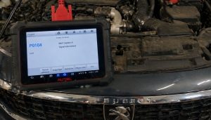 code p0104 affiché sur une valise branché sur le moteur d'une peugeot